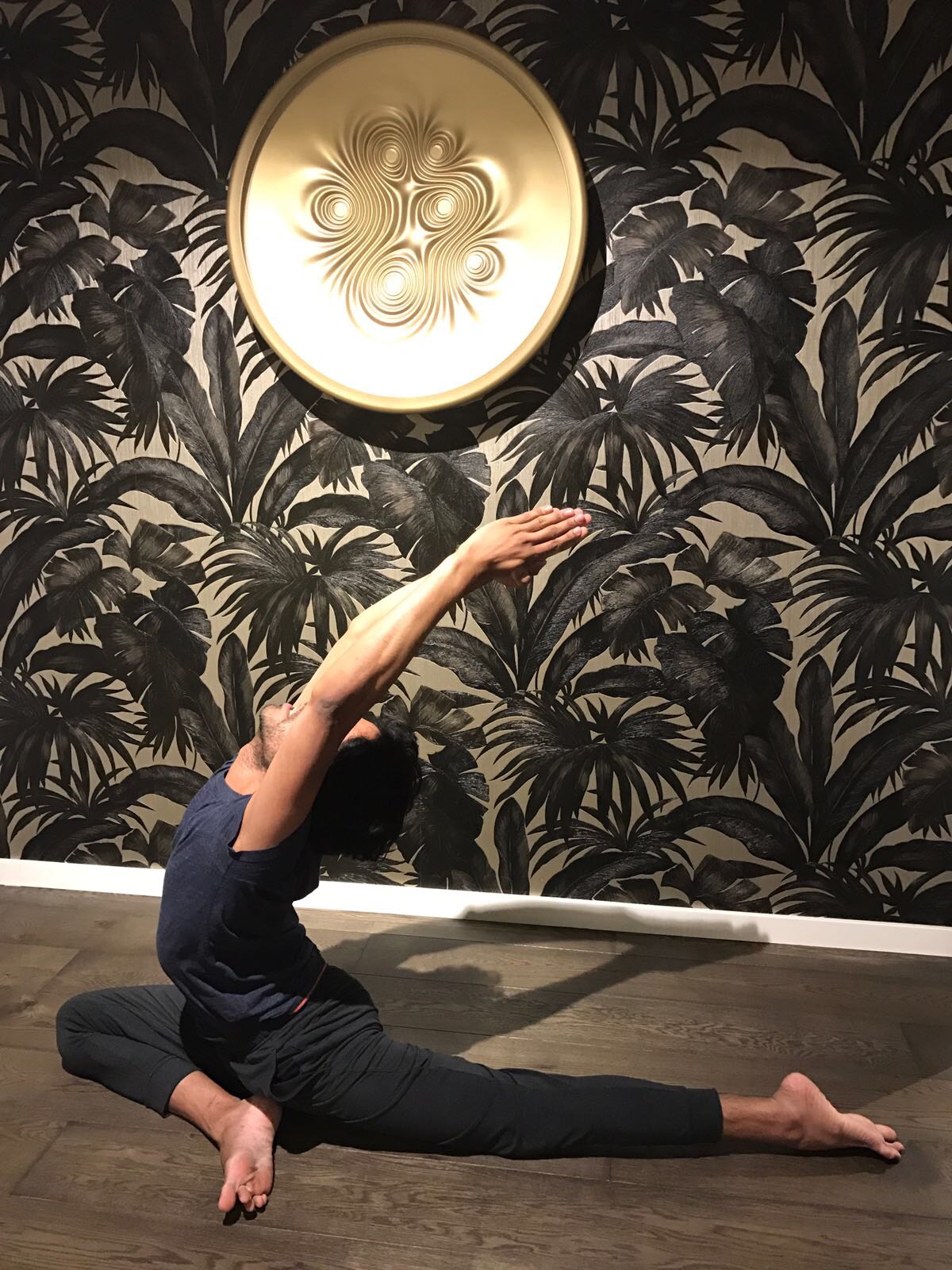 Farooq practising a seated pigeon variation with an overhead reach